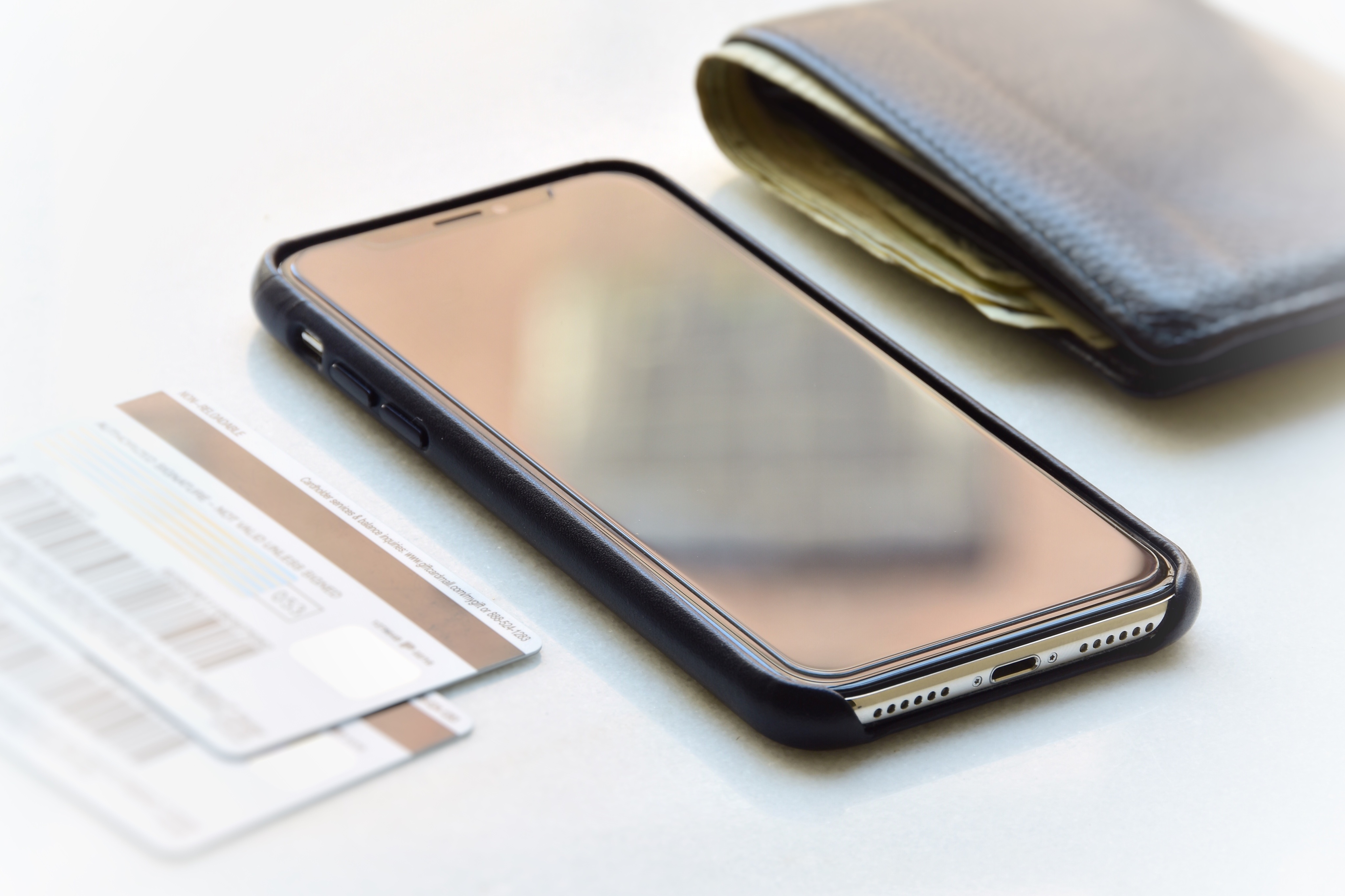 A cased smartphone resting beside credit cards and a wallet