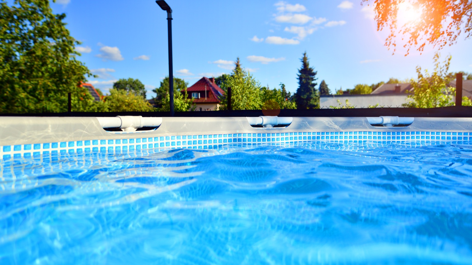 A clean, well-maintained above-ground backyard pool with clear blue water on a sunny day