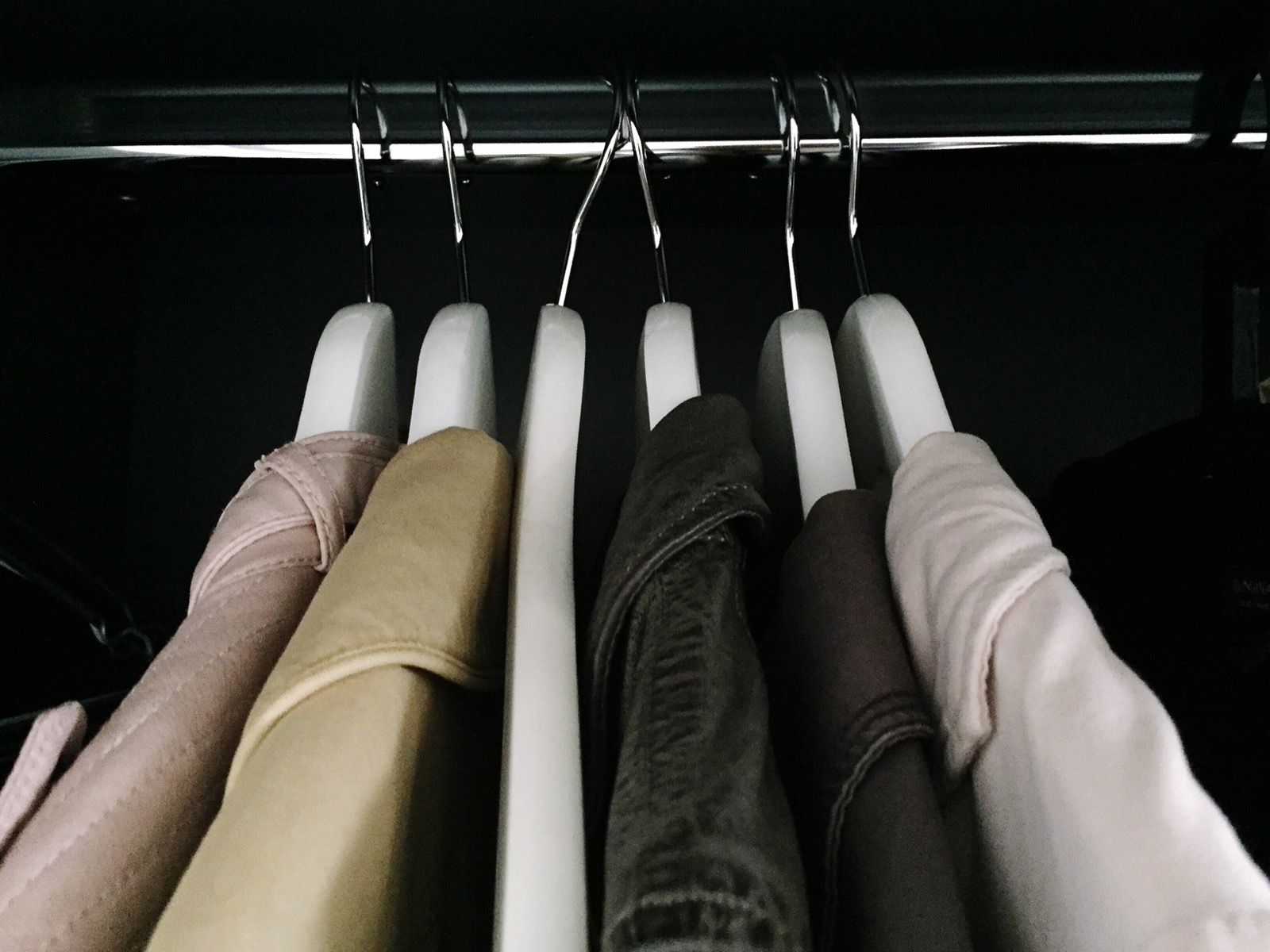 A closet rail of matched slim hangers holding shirts and jackets
