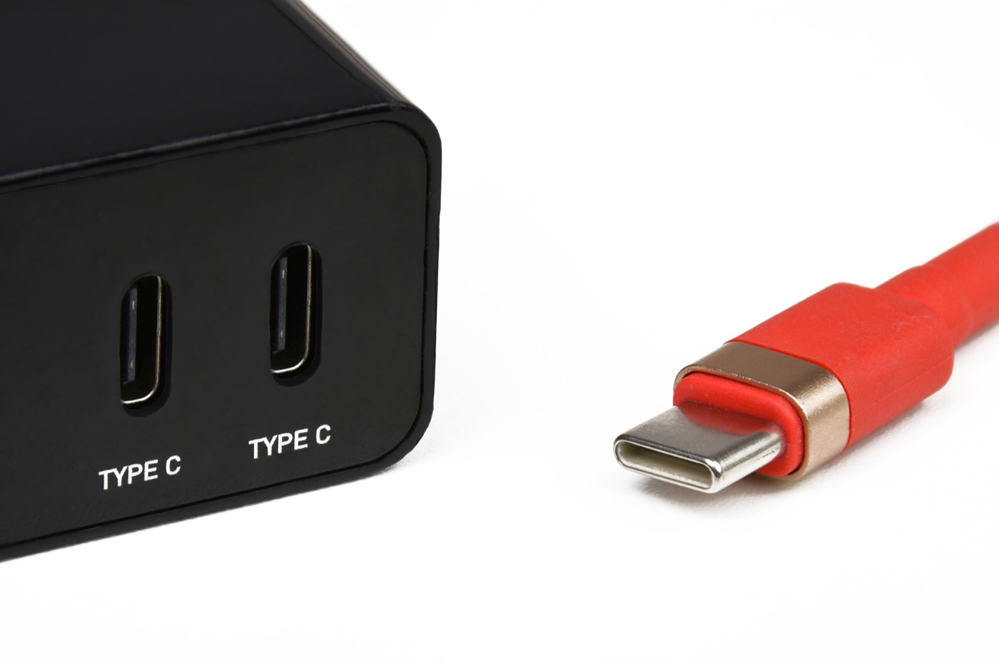 A USB-C power adapter with dual Type-C ports beside a USB-C charging cable