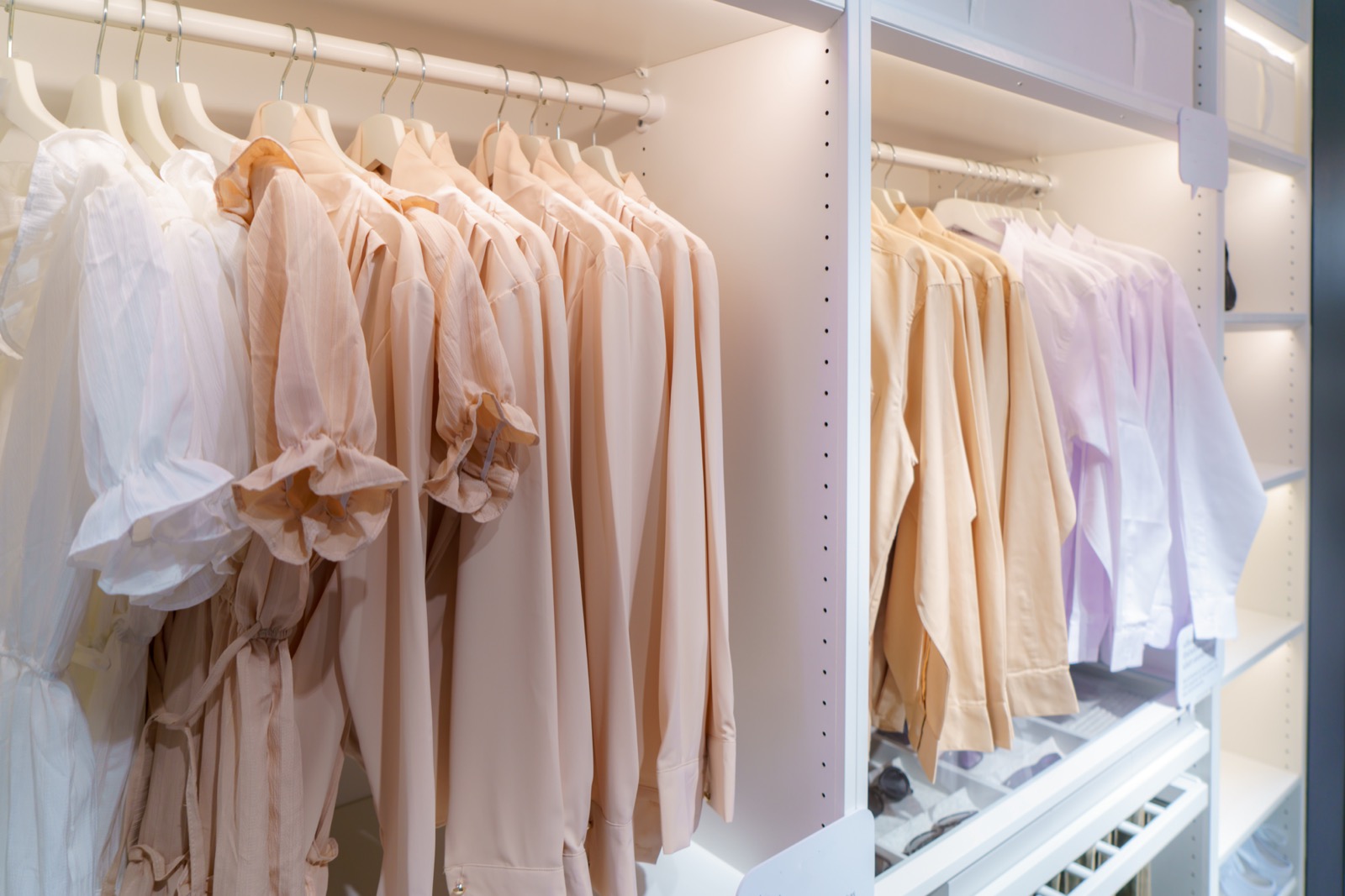 An airy white wardrobe with garments hanging on rails with breathing room between them