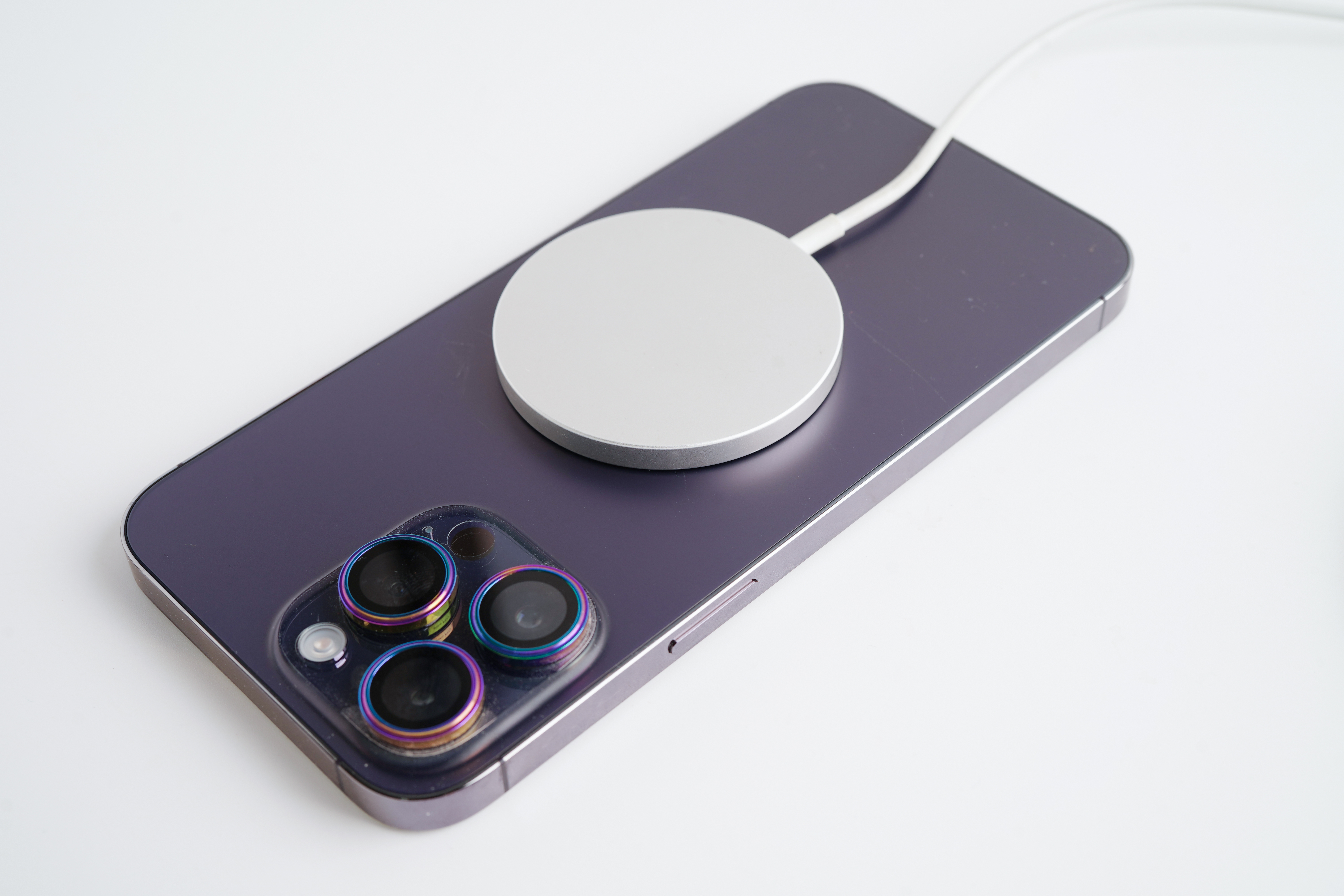 An Apple MagSafe wireless charger magnetically snapped onto the back of an iPhone