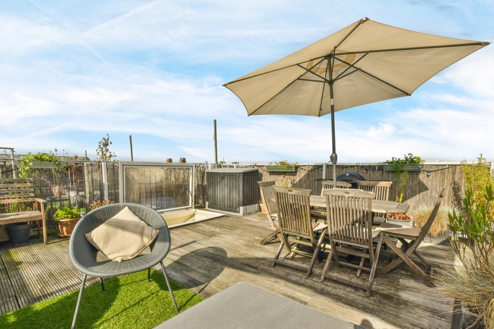 Beige patio umbrella shading an outdoor dining table on a terrace