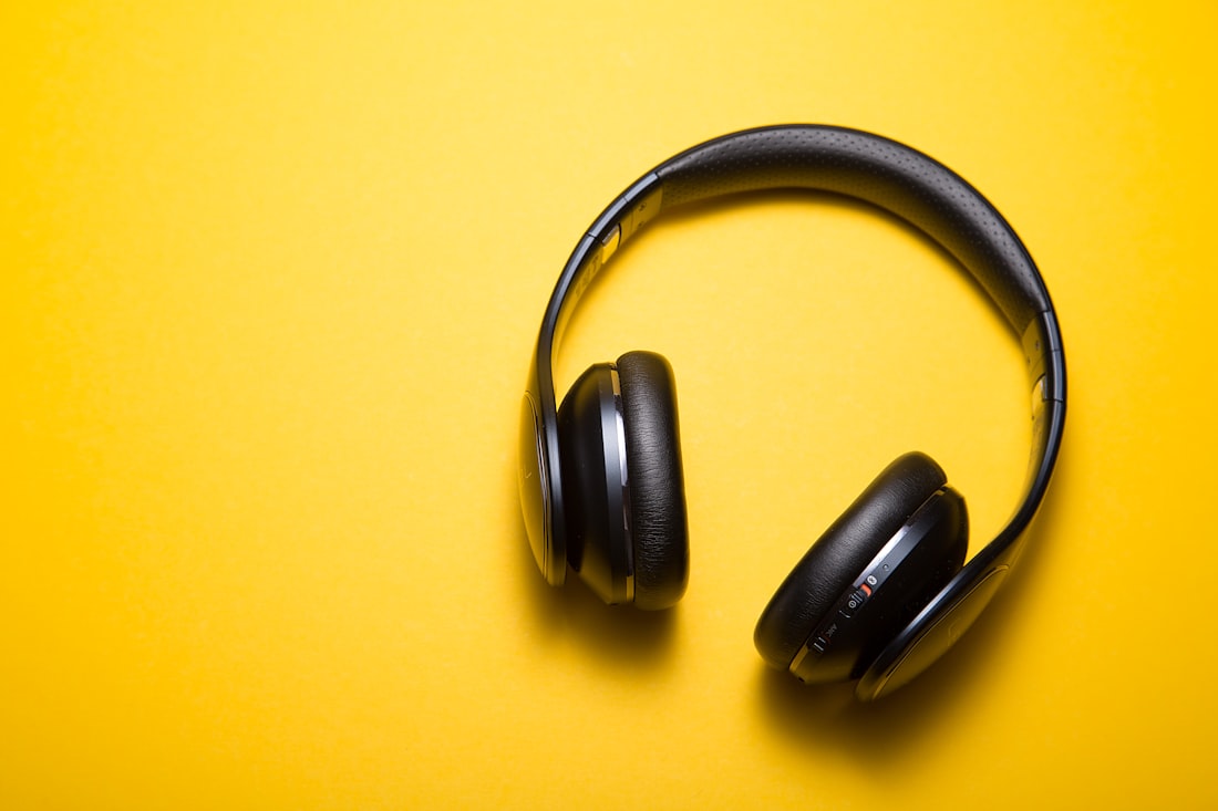 Black wireless over-ear headphones on a yellow background