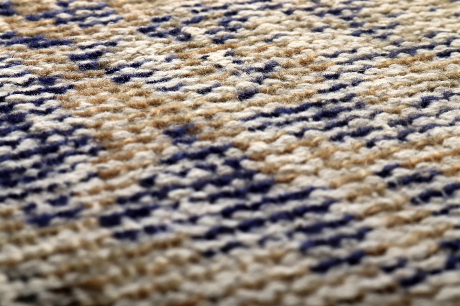 Close-up of a low-pile cotton flatweave entry rug showing a tight multi-tone boho pattern