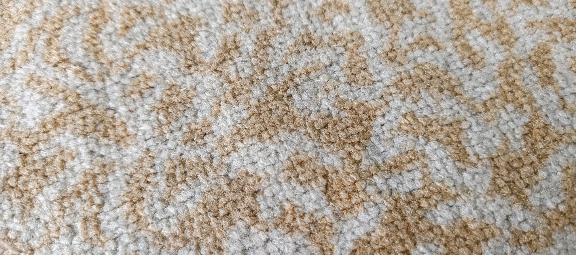 Close-up of a synthetic washable rug pile showing its low-pile textured weave