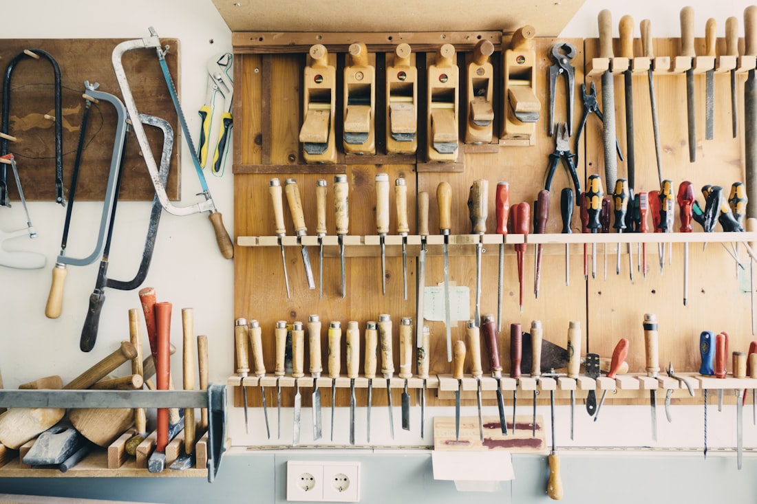 Open household tool kit showing hand tools, bits, and a compact drill