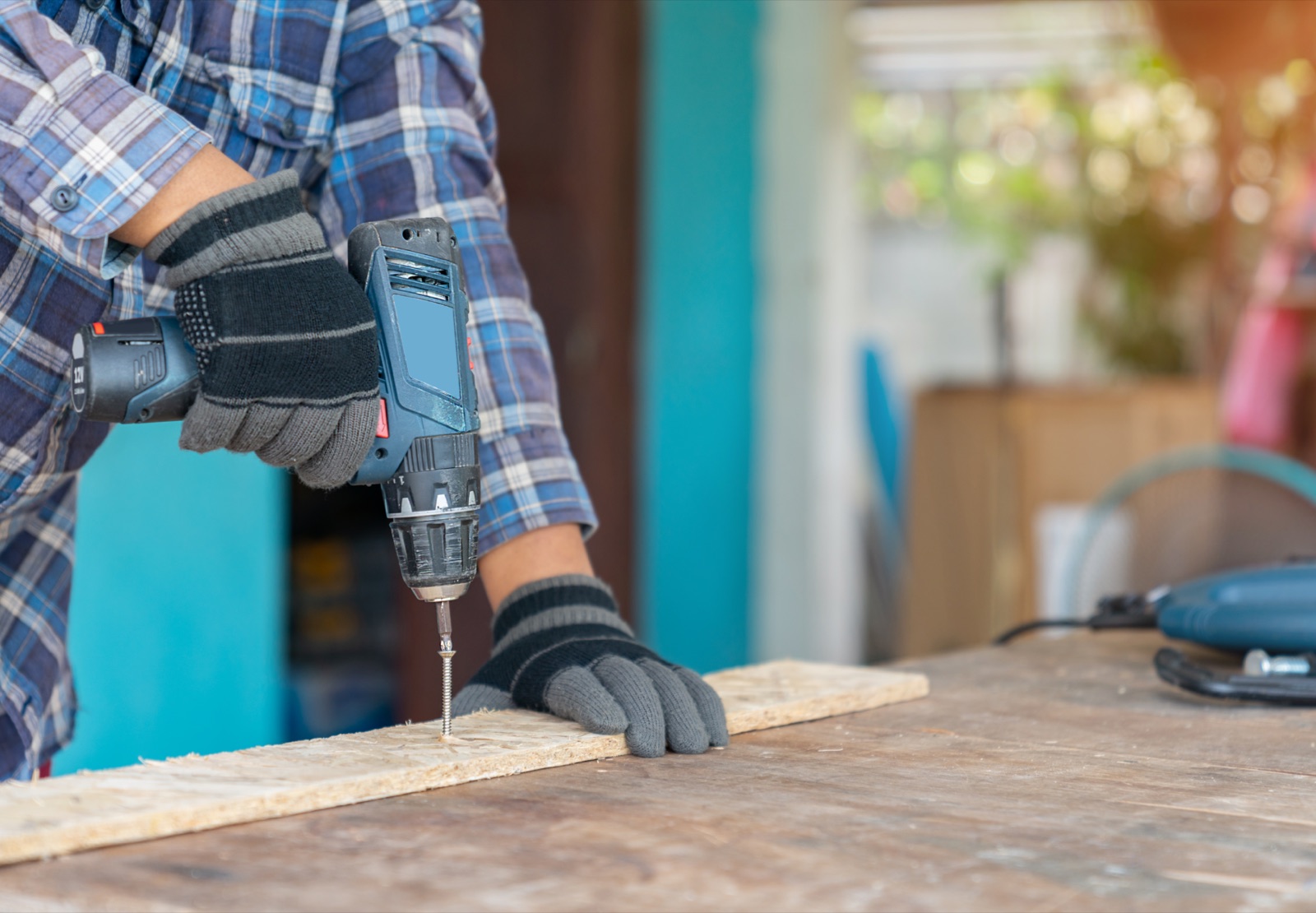 Driving a screw into a wood board with a cordless brushless drill driver