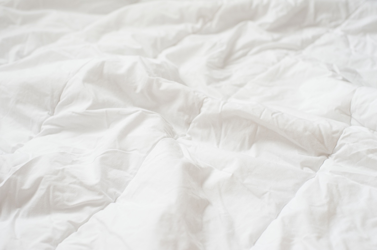 Macro view of a breathable, lofted white comforter fabric