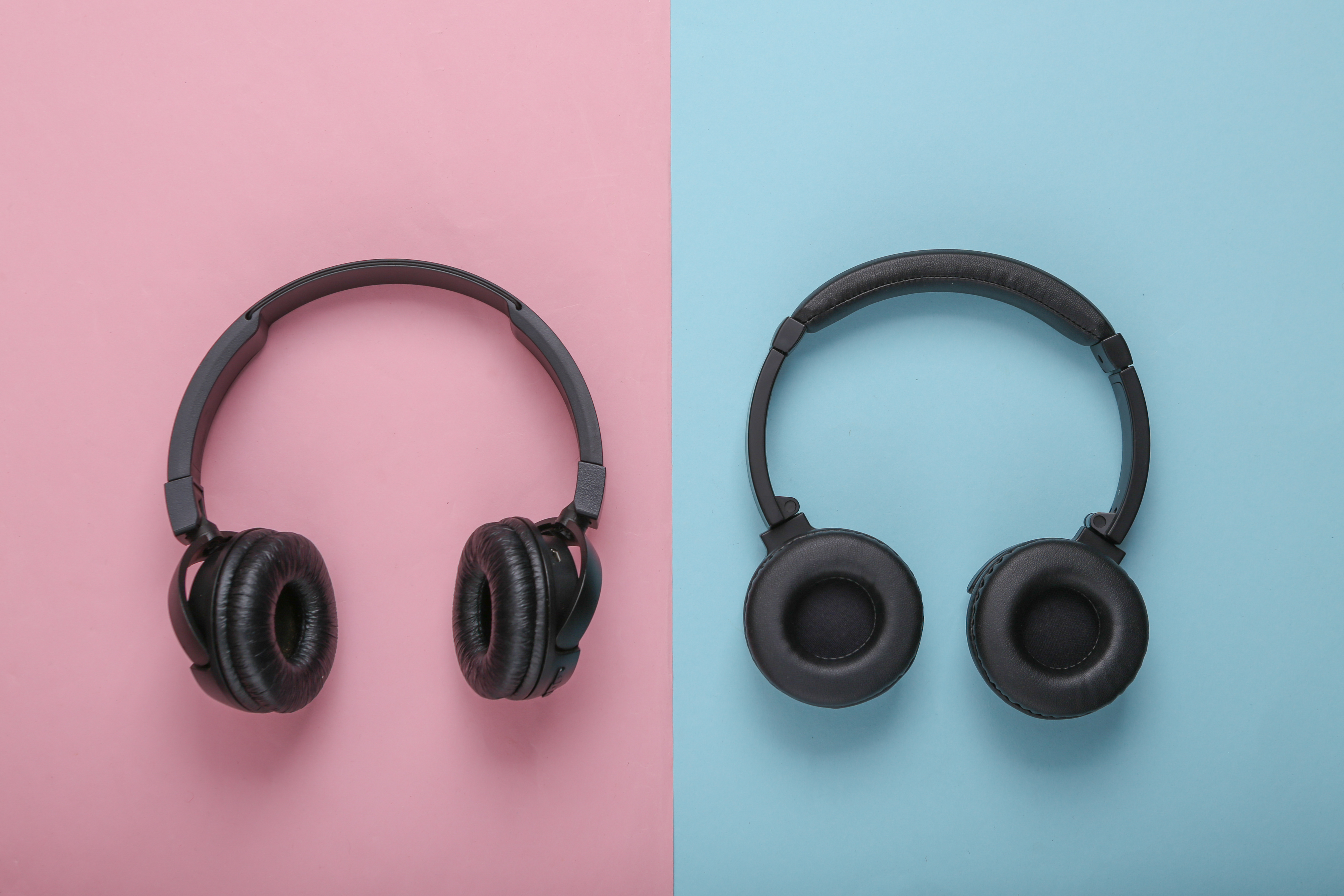 Two pairs of black wireless over-ear headphones side by side, comparing two models